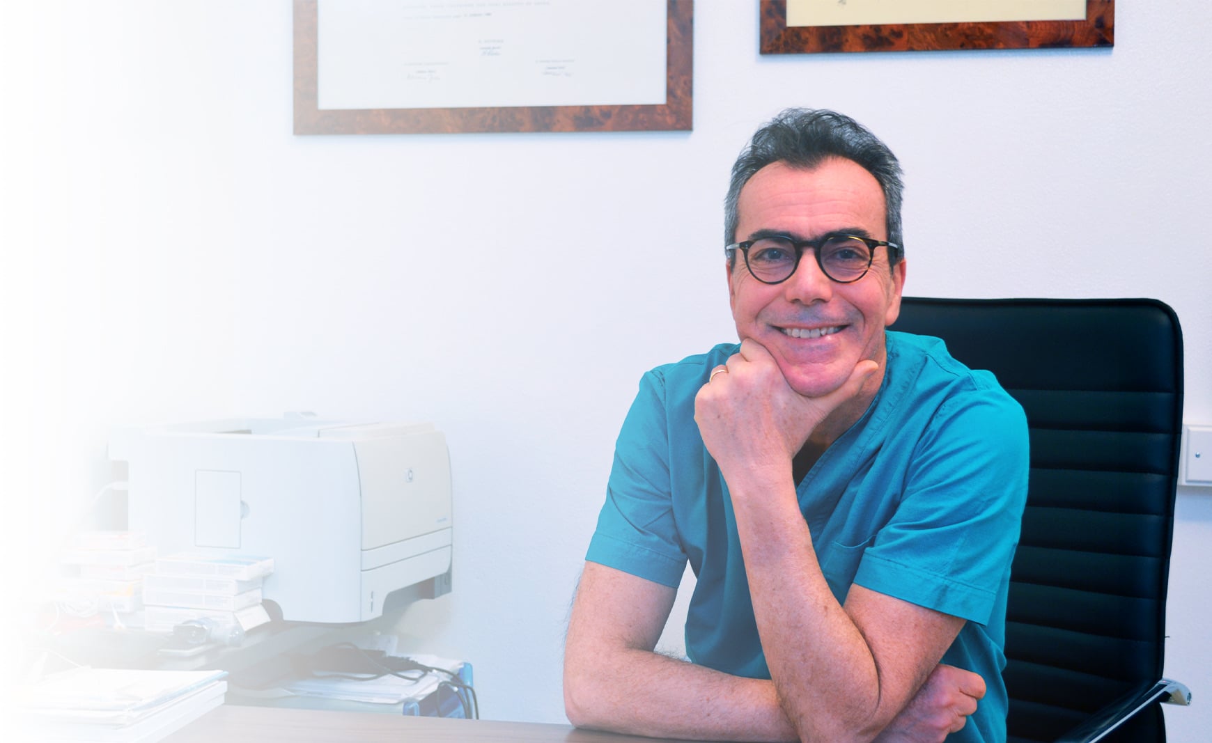Il Dott. Pierluigi Martina, oculista, seduto alla scrivania del suo studio di Ferrara